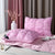 Pink quilted comforter and pillow on a bed with decorative elements.