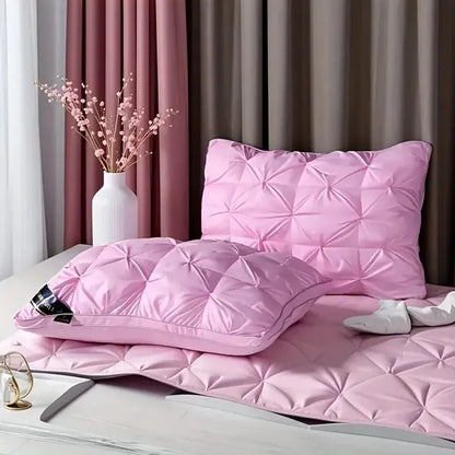 Pink quilted comforter and pillow on a bed with decorative elements.