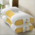 White and yellow orthopedic pillow on a bed in a bedroom setting